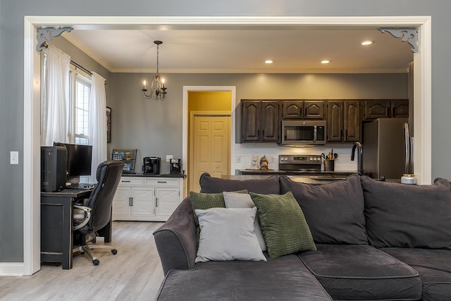 living room featuring crown molding, a notable chandelier, and light hardwood / wood-style flooring