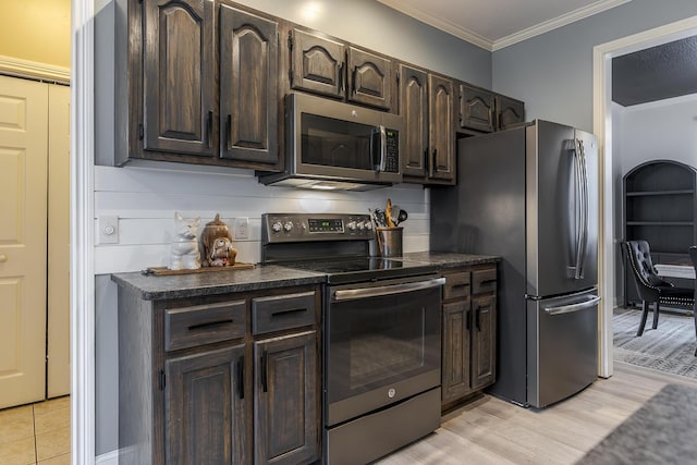 kitchen with ornamental molding, appliances with stainless steel finishes, light hardwood / wood-style floors, and dark brown cabinetry