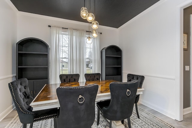 dining space featuring crown molding and light hardwood / wood-style floors