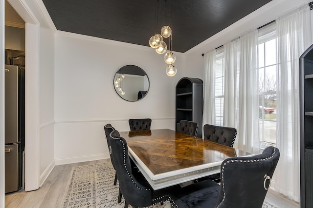 dining room with ornamental molding and light wood-type flooring