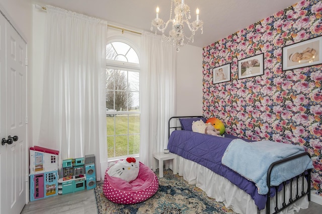 bedroom with a notable chandelier and hardwood / wood-style flooring