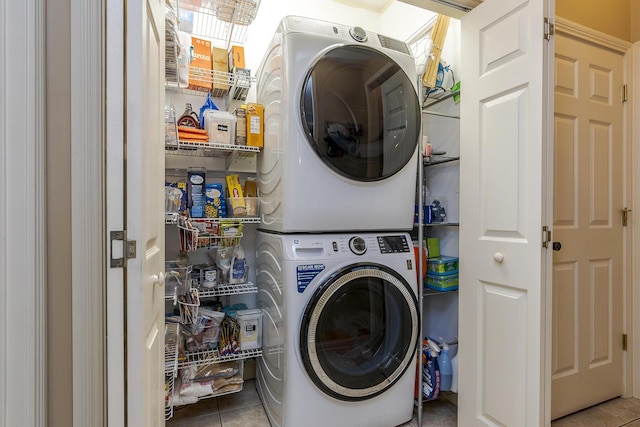 washroom featuring stacked washer / drying machine and light tile patterned floors