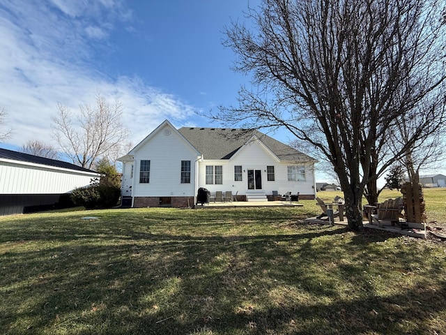 rear view of property featuring a lawn and a patio