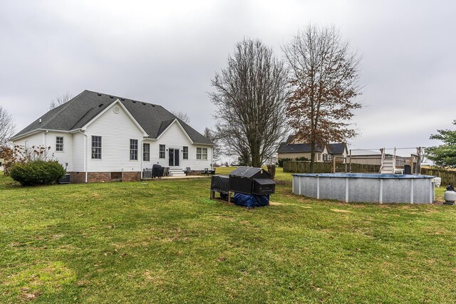 rear view of property with a yard and cooling unit