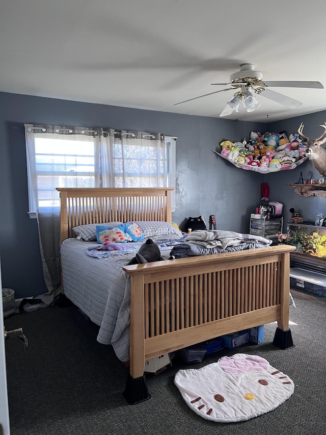 bedroom featuring a ceiling fan, multiple windows, and carpet flooring