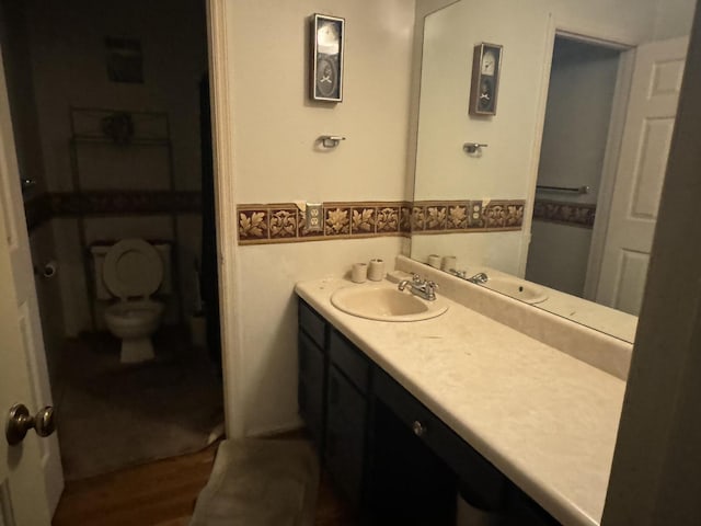 bathroom featuring vanity, hardwood / wood-style flooring, and toilet