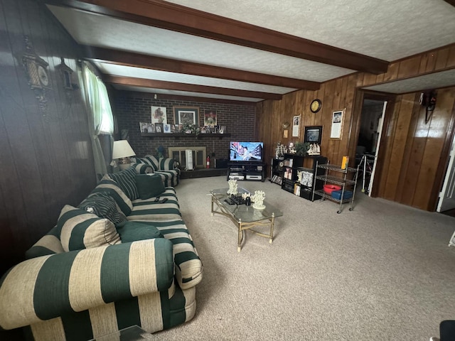 carpeted living room with beamed ceiling, a brick fireplace, wooden walls, and a textured ceiling