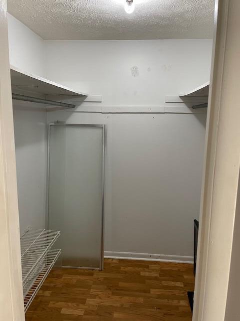 walk in closet with dark wood-type flooring