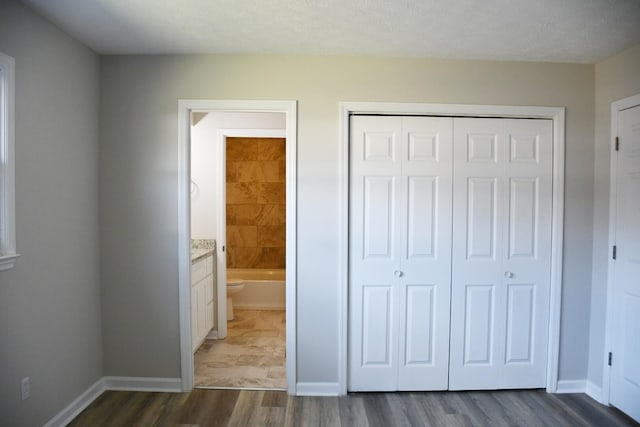 unfurnished bedroom featuring dark hardwood / wood-style floors and a closet