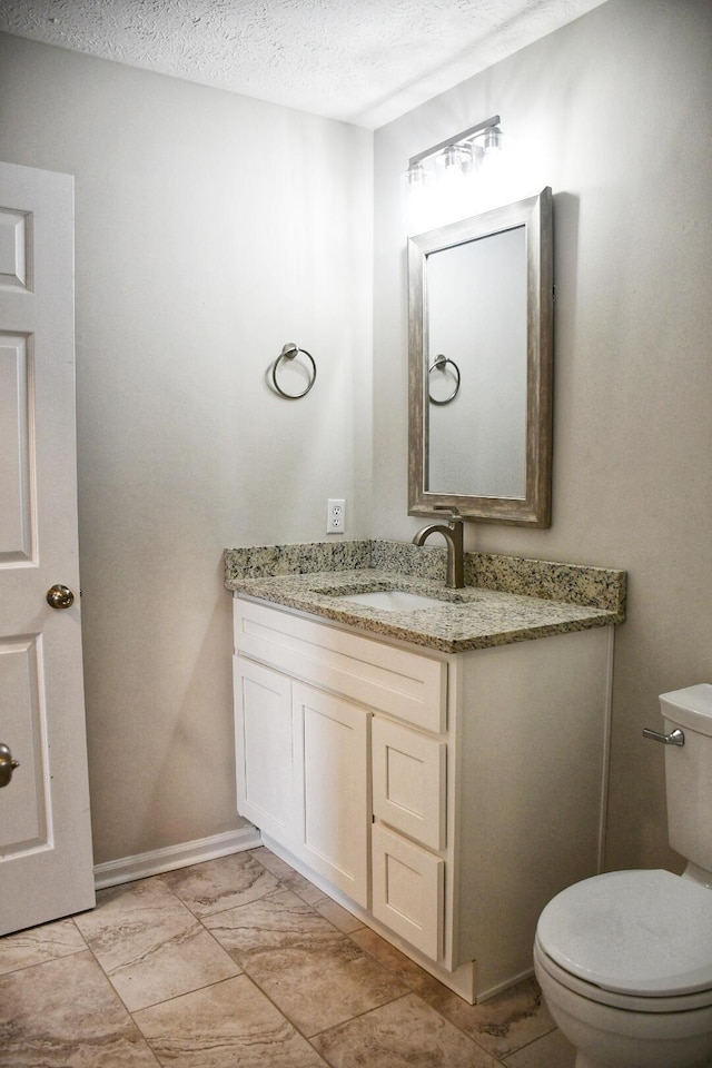 bathroom with vanity, a textured ceiling, and toilet