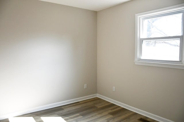 unfurnished room with dark wood-type flooring