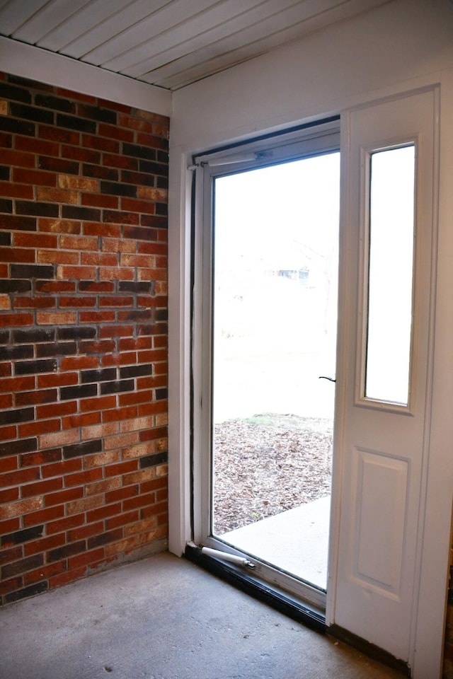 entryway featuring brick wall