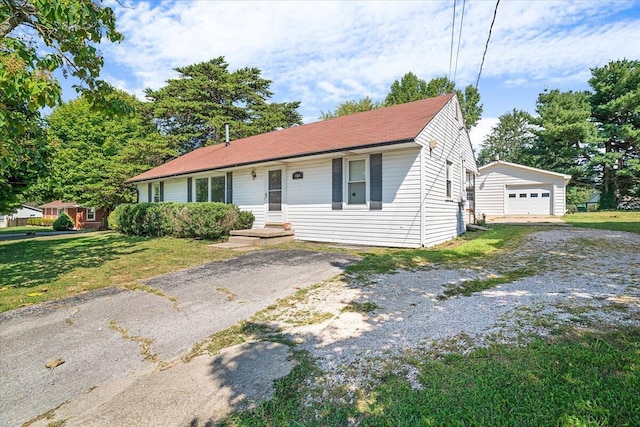 view of front of property with a garage, an outbuilding, and a front lawn