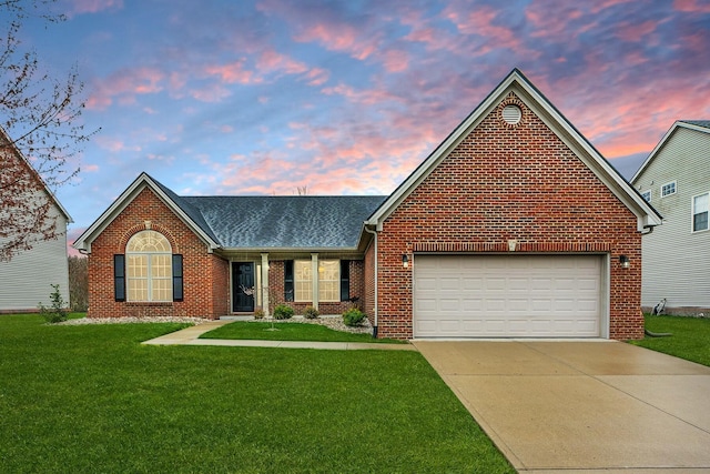 single story home with a garage, driveway, a yard, and brick siding