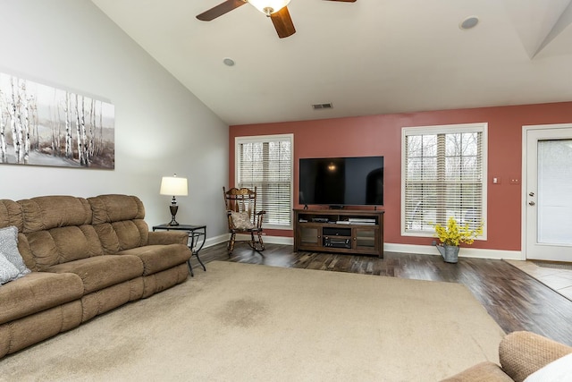 living area featuring baseboards, vaulted ceiling, visible vents, and dark wood finished floors