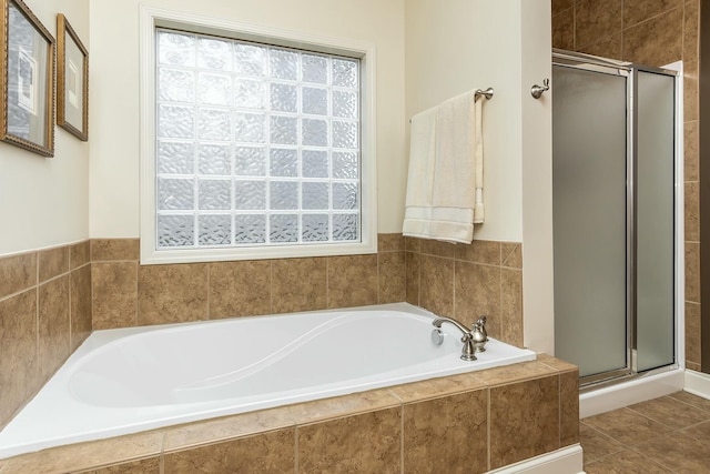 full bathroom featuring a stall shower, tile patterned flooring, and a garden tub