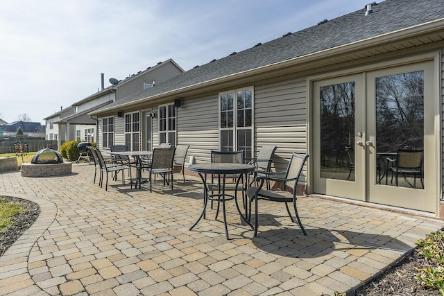 view of patio with fence, outdoor dining area, and french doors