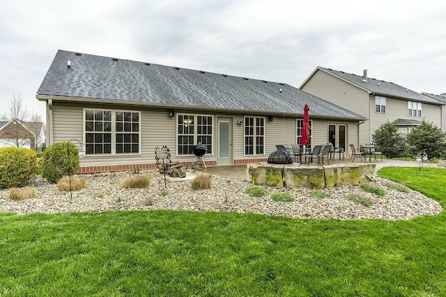 back of house featuring a fire pit, a patio, a yard, and roof with shingles