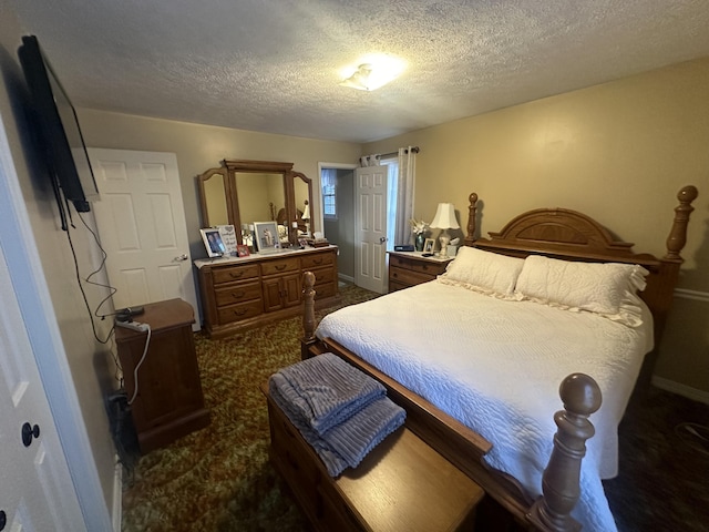 bedroom with dark carpet and a textured ceiling