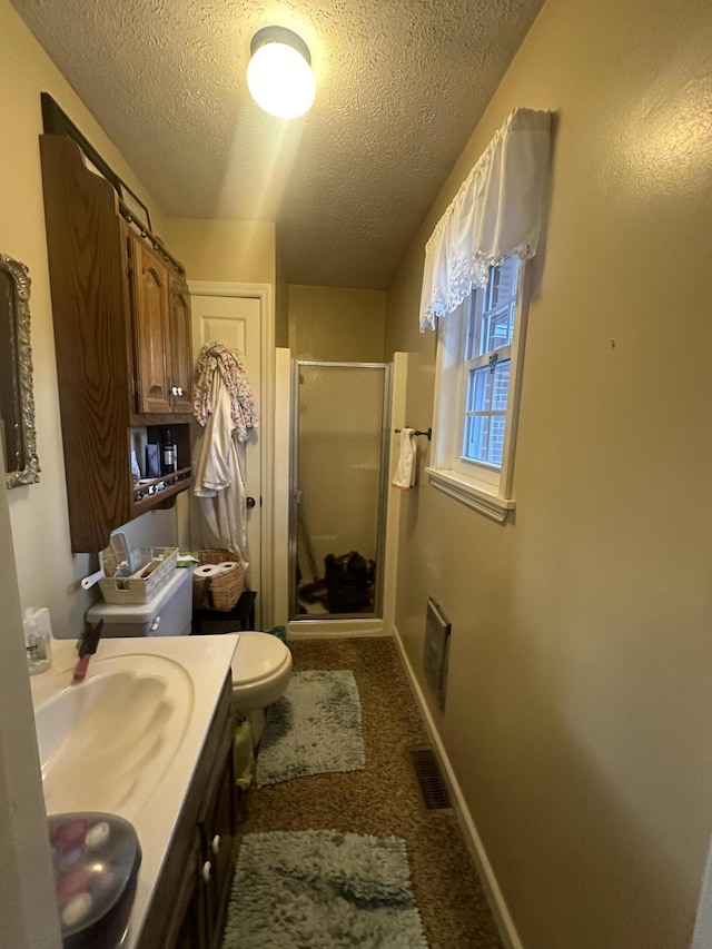 bathroom featuring vanity, an enclosed shower, a textured ceiling, and toilet