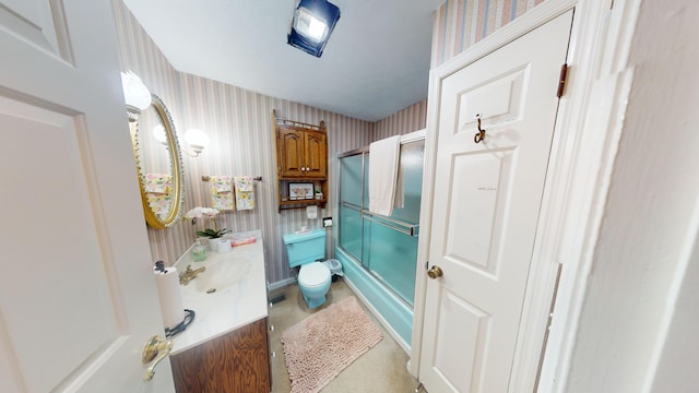 bathroom featuring bath / shower combo with glass door, vanity, toilet, and wallpapered walls