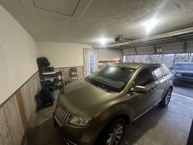 garage with a garage door opener and wooden walls