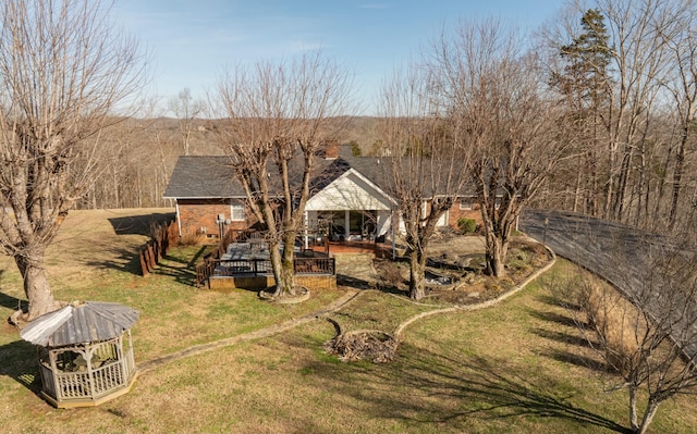 exterior space with a yard, a shingled roof, and a wooden deck