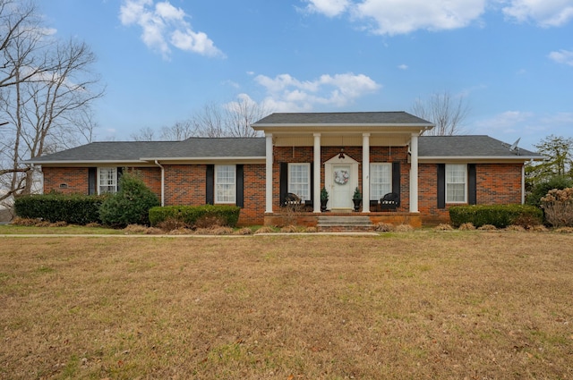 greek revival inspired property with a front yard and brick siding