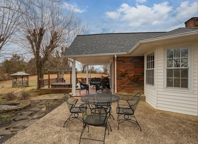 view of patio / terrace with a hot tub and outdoor dining space