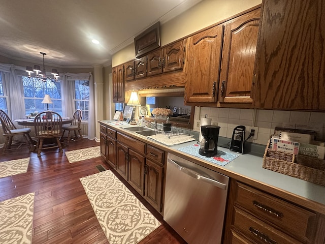 kitchen featuring crown molding, dark wood-type flooring, dishwasher, decorative backsplash, and decorative light fixtures