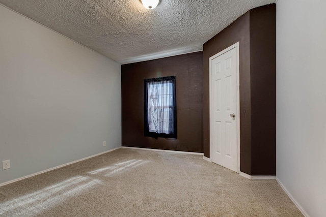 carpeted spare room with a textured ceiling