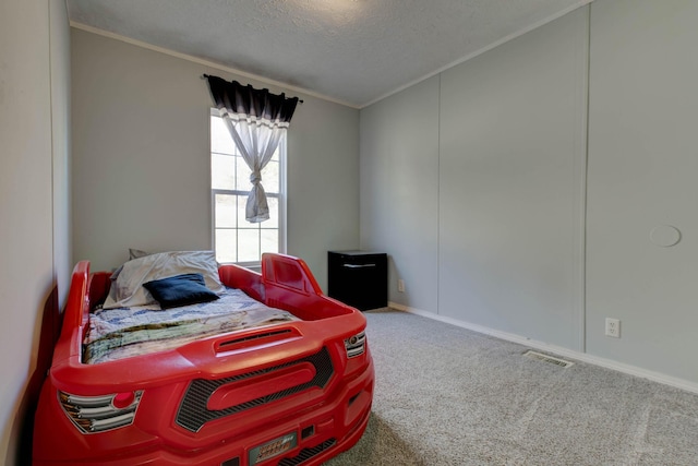 bedroom with ornamental molding, a textured ceiling, and carpet flooring