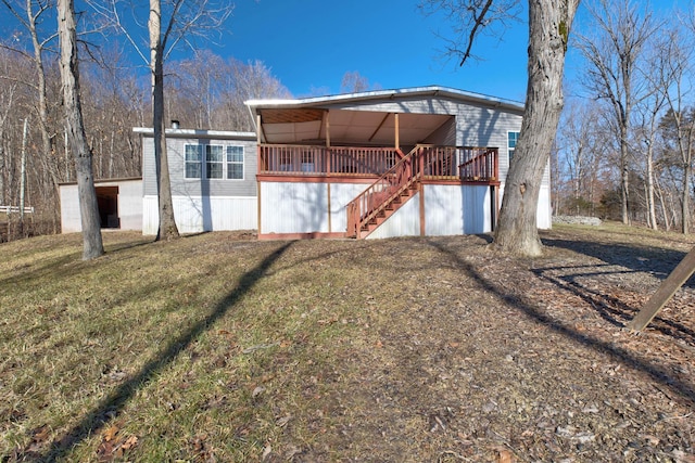 rear view of house featuring a wooden deck and a lawn