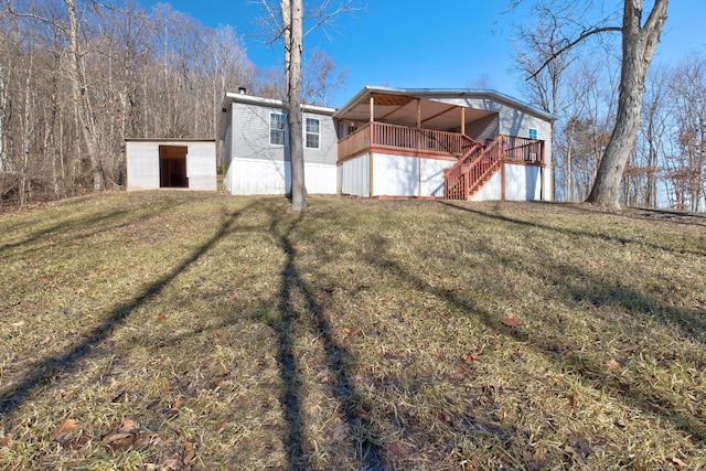 back of house with a wooden deck and a lawn