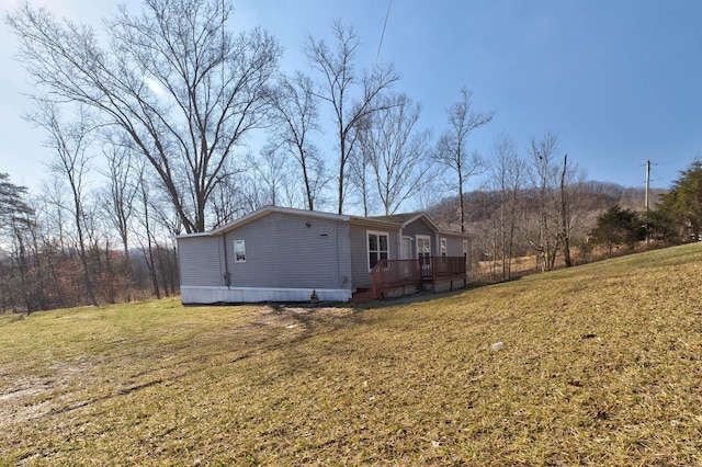 view of side of home featuring a yard and a deck