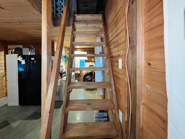 stairway featuring wood walls