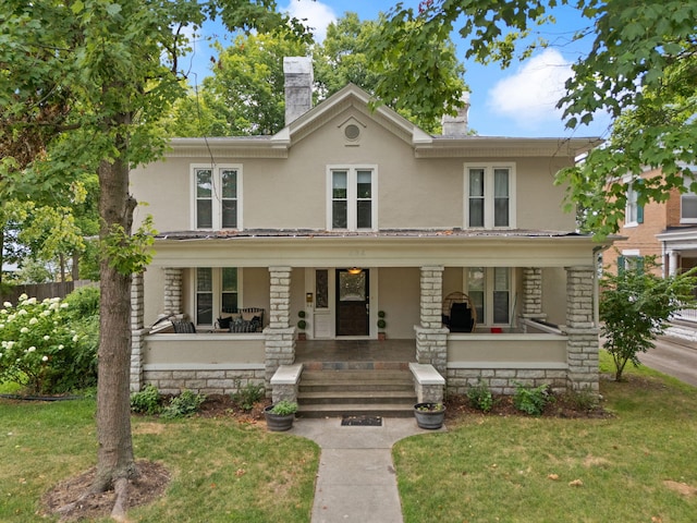 view of front of house with covered porch and a front lawn