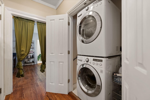 washroom with dark hardwood / wood-style flooring, ornamental molding, and stacked washing maching and dryer