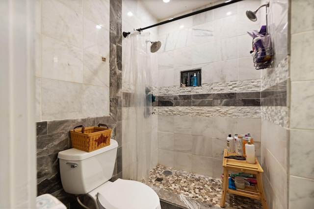 bathroom with tile walls, toilet, and a shower with shower curtain