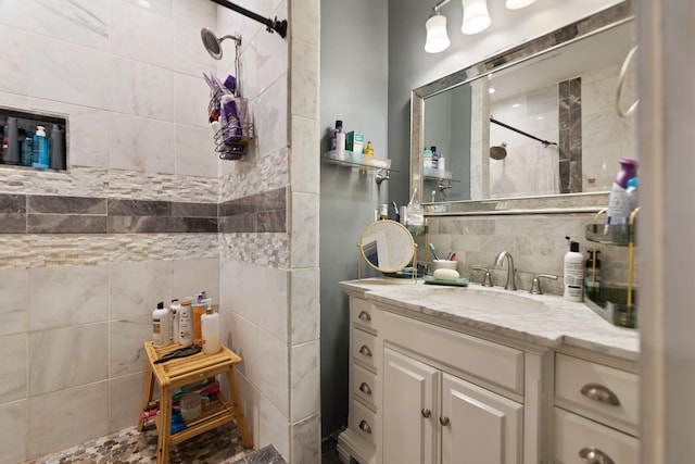 bathroom with tasteful backsplash, vanity, and tiled shower