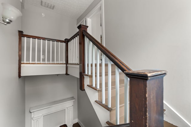 stairs with a textured ceiling