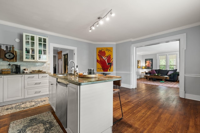 kitchen with sink, dark wood-type flooring, a breakfast bar area, white cabinetry, and a center island with sink