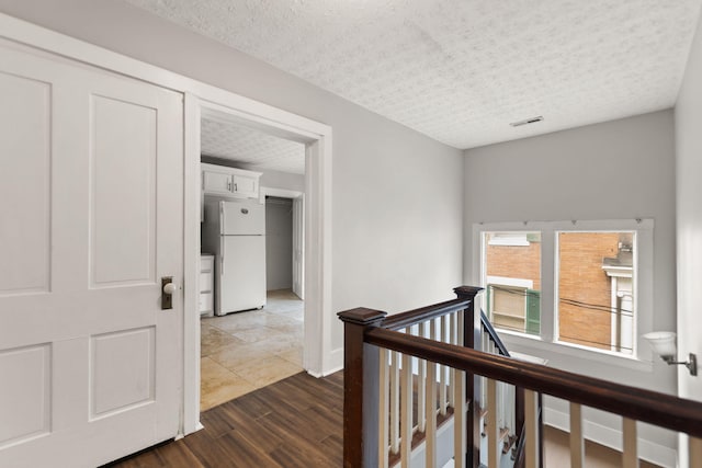 corridor featuring dark hardwood / wood-style floors and a textured ceiling