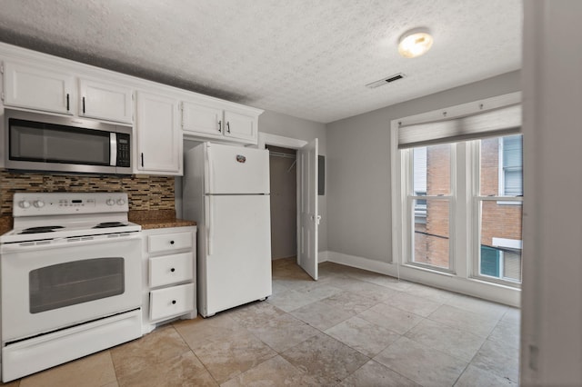 kitchen featuring backsplash, white appliances, a textured ceiling, and white cabinets