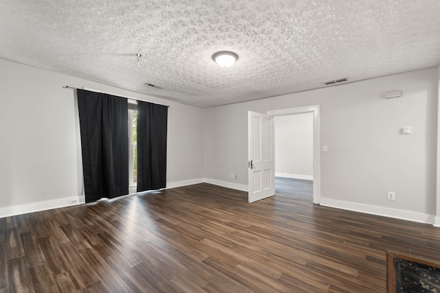 spare room with dark hardwood / wood-style flooring and a textured ceiling