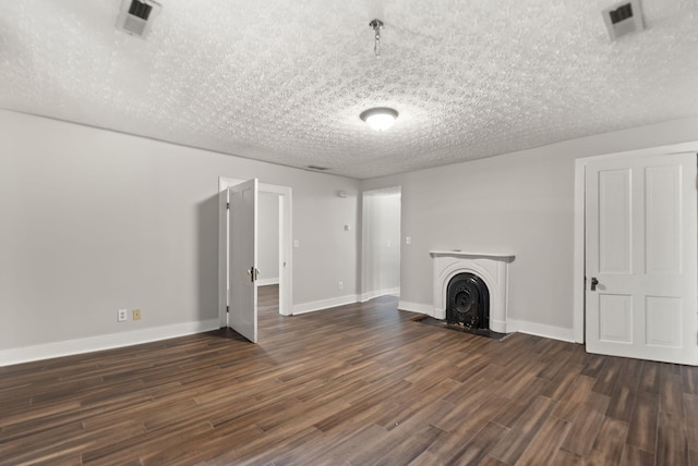 unfurnished living room with dark wood-type flooring and a textured ceiling