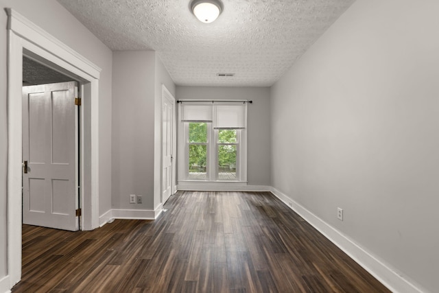 unfurnished room featuring dark hardwood / wood-style floors and a textured ceiling