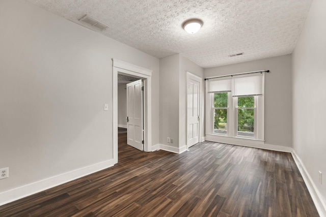 unfurnished room with dark wood-type flooring and a textured ceiling