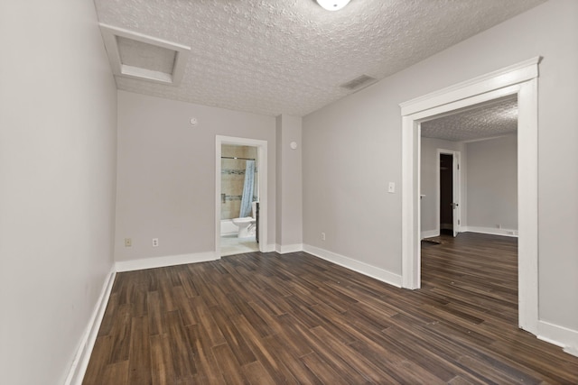 spare room featuring dark hardwood / wood-style flooring and a textured ceiling