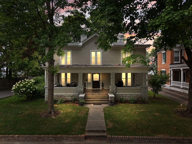 view of front of house featuring a porch and a yard